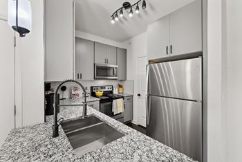 A kitchen with a stainless steel refrigerator and a sink with a black faucet. at Preserve at Rolling Oaks, Texas, 78728